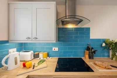 a kitchen with a counter top with blue tiles at Perfect place for family time in Hayle