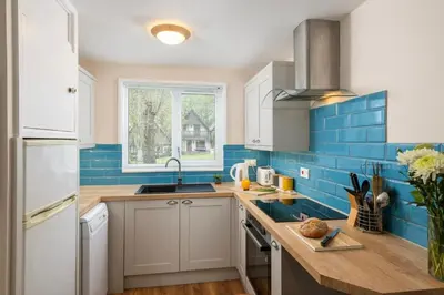 a kitchen with blue tiles on the wall at Perfect place for family time in Hayle
