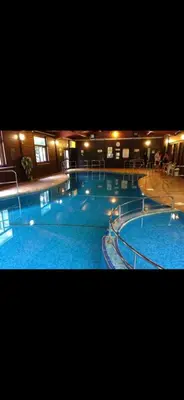 a large swimming pool with blue water in a building at Perfect place for family time in Hayle