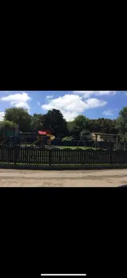 a fence in front of a park with trees at Perfect place for family time in Hayle
