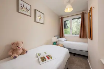 a teddy bear sitting on a bed in a room at Perfect place for family time in Hayle