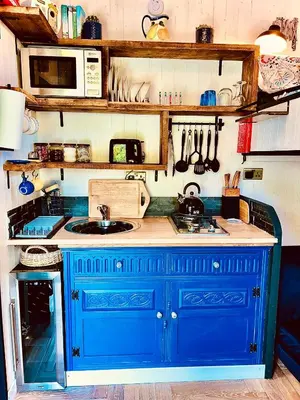a blue kitchen with a sink and a microwave at Hillhead Hideaway in Saint Columb Major