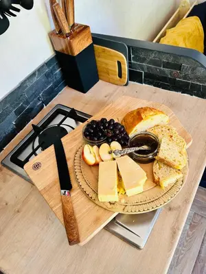 a plate of cheese and bread on a cutting board at Hillhead Hideaway in Saint Columb Major