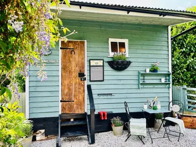 a blue house with a table and chairs outside at Hillhead Hideaway in Saint Columb Major