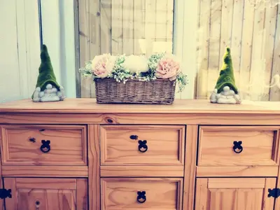 a dresser with flowers in baskets on top of it at Holm Cottage near Charlestown in St Austell