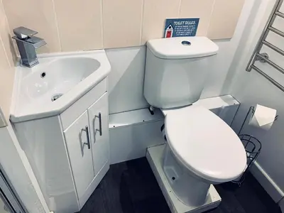 a small bathroom with a toilet and a sink at Holm Cottage near Charlestown in St Austell