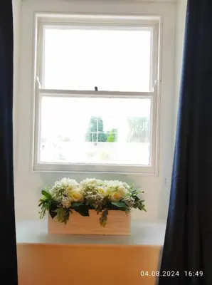 a vase of flowers sitting on a window sill at Holm Cottage near Charlestown in St Austell