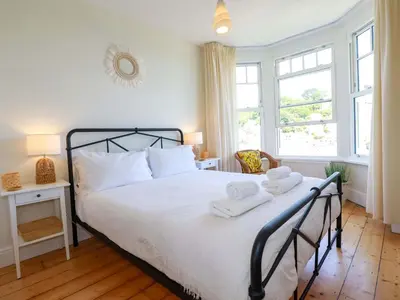 a bedroom with a bed with two towels on it at Harbour House in Looe