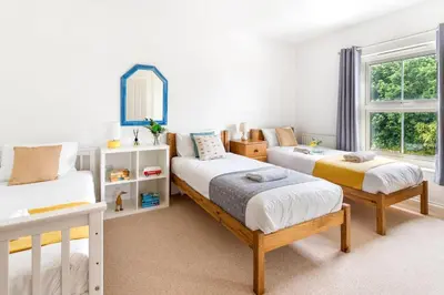 a bedroom with two beds and a mirror at Peaceful - 10-min walk to beach - The White House in Falmouth