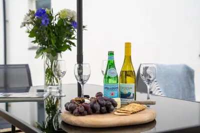 a table with two bottles of wine and wine glasses at Peaceful - 10-min walk to beach - The White House in Falmouth