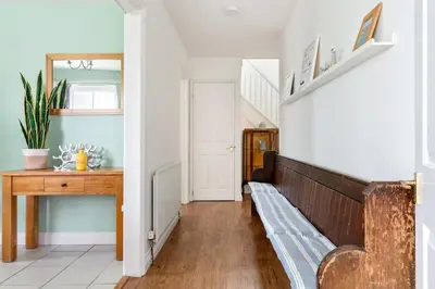 a hallway with a wooden bench in a house at Peaceful - 10-min walk to beach - The White House in Falmouth