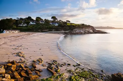 a view of a beach with rocks in the water at Peaceful - 10-min walk to beach - The White House in Falmouth