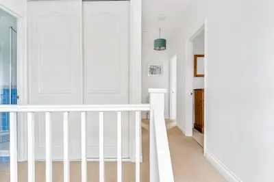 a white staircase in a room with white walls at Peaceful - 10-min walk to beach - The White House in Falmouth