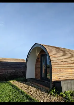 a small house with a wooden roof at Glamping Pod in Mawgan Porth
