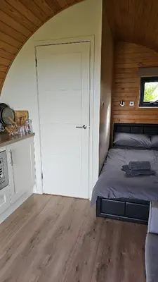 a bedroom with a bed and a door in a room at Glamping Pod in Mawgan Porth