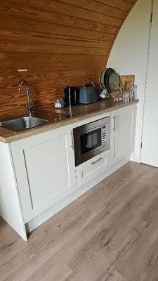 a kitchen with a sink and a microwave at Glamping Pod in Mawgan Porth