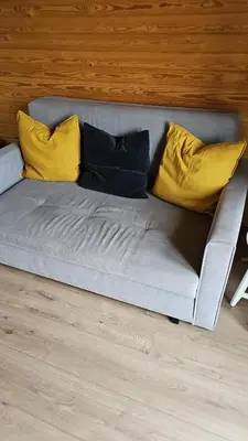 a couch with yellow pillows on top of it at Glamping Pod in Mawgan Porth