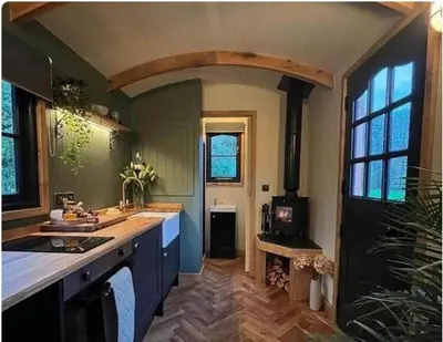a kitchen with a sink and a stove at Shepherds Hut in Mawgan Porth