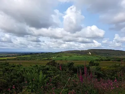 a view of a green field with a cloudy sky at Bell Tent 1 in St Austell