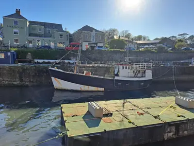 two boats are docked at a dock in the water at Bell Tent 1 in St Austell