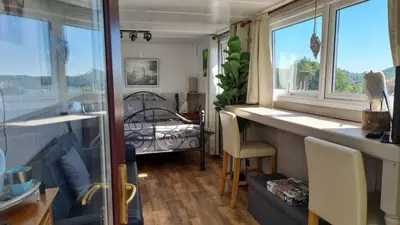 a room with windows and a room with a bedroom at The Cabin in St Austell