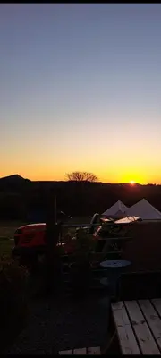 a sunset with the sun setting in the distance at The Cabin in St Austell
