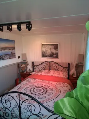 a bedroom with a bed with a red and white bedspread at The Cabin in St Austell