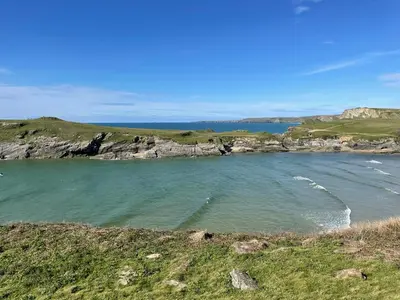 a large body of water with rocks in the ocean at Glendorgal Sands - The best sea views in Cornwall in Saint Columb Minor