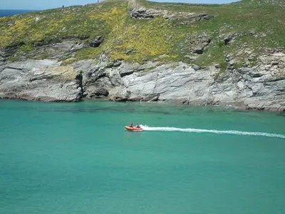 a group of people in a boat in the water at Glendorgal Sands - The best sea views in Cornwall in Saint Columb Minor