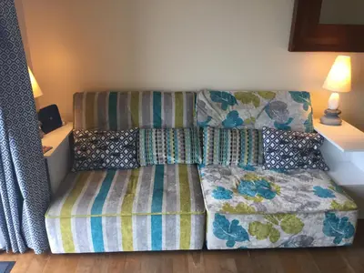 a bed and a couch in a room at Glendorgal Sands - The best sea views in Cornwall in Saint Columb Minor