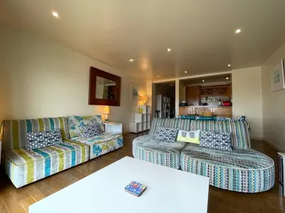 a living room with two couches and a table at Glendorgal Sands - The best sea views in Cornwall in Saint Columb Minor