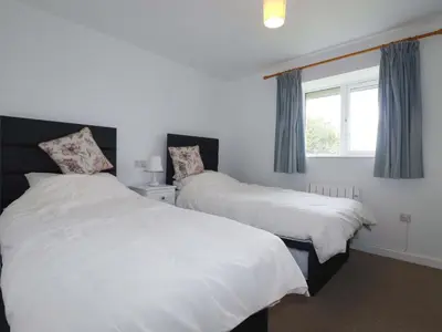 two beds in a room with a window at Folly View in Redruth