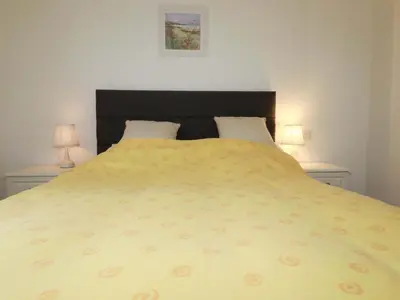 a bedroom with a large yellow bed with two lamps at Folly View in Redruth