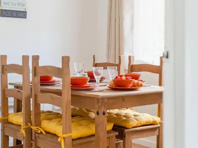 a wooden table with plates and wine glasses on it at Chalet The Birches by Interhome in Liskeard