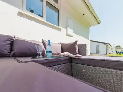 a table with a bottle and a glass on a patio at Chalet The Birches by Interhome in Liskeard