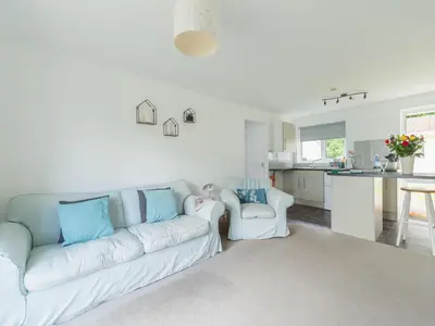 a living room with a white couch and a kitchen at Chalet The Birches by Interhome in Liskeard