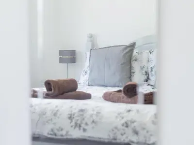 a white bed with two towels on top of it at Chalet Rosecraddoc Lodges by Interhome in Liskeard