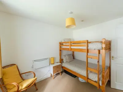 a bedroom with a bunk bed and a chair at Chalet Rosecraddoc Lodges by Interhome in Liskeard
