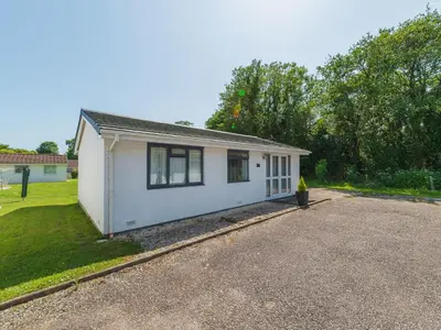a small white house on a gravel road at Chalet Bliss by Interhome in Liskeard