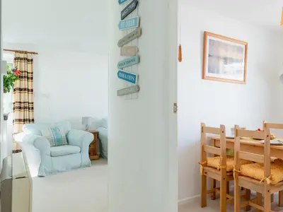 a living room with a blue chair and a table at Chalet Bliss by Interhome in Liskeard