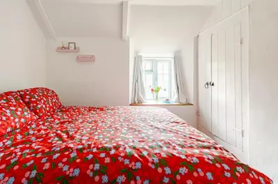 a red bedspread with flowers on it in a bedroom at Captains Ground in Altarnun