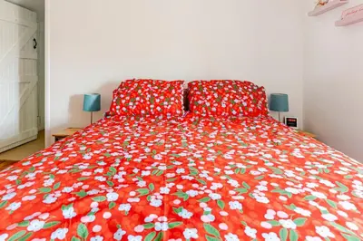 a bedroom with a red bedspread with flowers on it at Captains Ground in Altarnun
