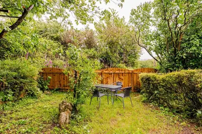 a picnic table in a yard with a fence at Captains Ground in Altarnun