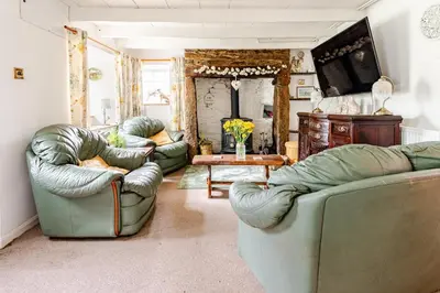 a living room with two couches and a table at Captains Ground in Altarnun