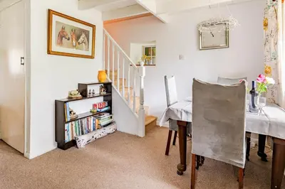 a living room with a dining room table and a staircase at Captains Ground in Altarnun
