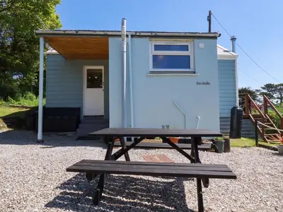 a picnic table in front of a tiny house at The Studio in Truro