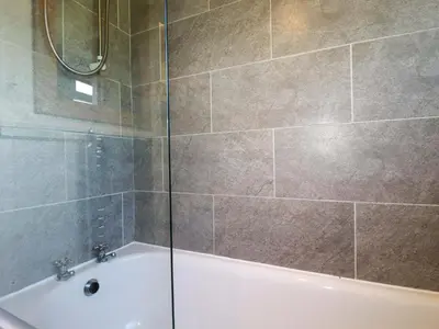 a bathroom with a shower and a bath tub at The Studio in Truro