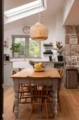 a kitchen with a wooden table with a bowl of fruit on it at Naut Retreat - Idyllic hideaway with hot tub, gym & gamesroom ideally located in Zennor near St Ives in Penzance