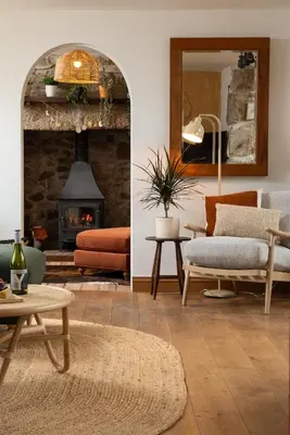 a living room filled with furniture and a fireplace at Naut Retreat - Idyllic hideaway with hot tub, gym & gamesroom ideally located in Zennor near St Ives in Penzance