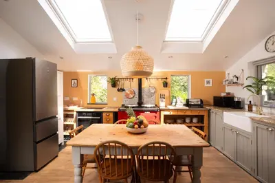 a kitchen with a table with a bowl of fruit on it at Naut Retreat - Idyllic hideaway with hot tub, gym & gamesroom ideally located in Zennor near St Ives in Penzance